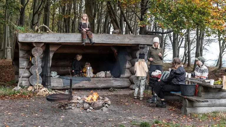 Familie på shelterplads med bål