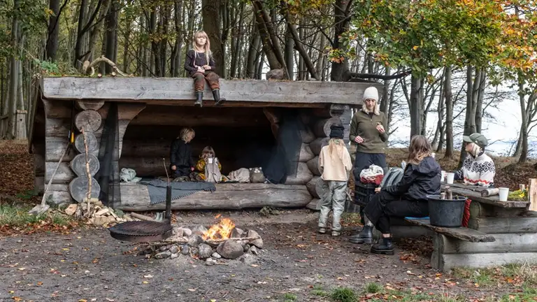 Familie på shelterplads med bål