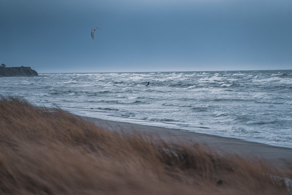 Kitesurfer i oprørt hav ved Klintholm Havn Øst strand