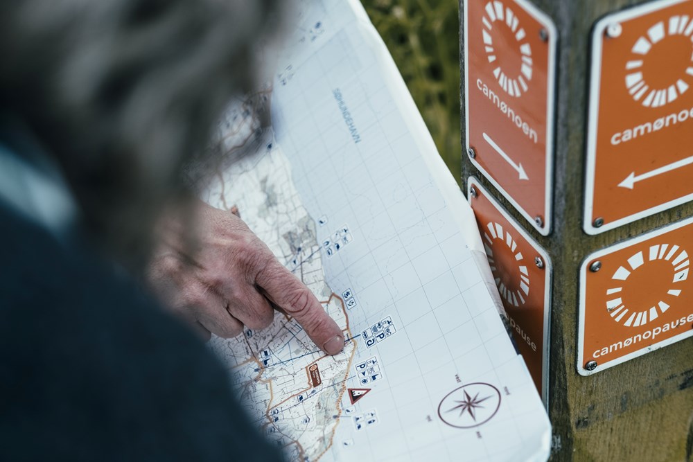 Hånd peger på vandrerute på kort over Camønoen af fotograf Frame Work for SydkystDanmark
